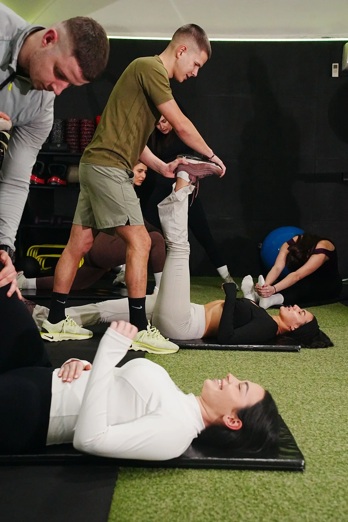 A coach assists a member during a mobility exercise.
