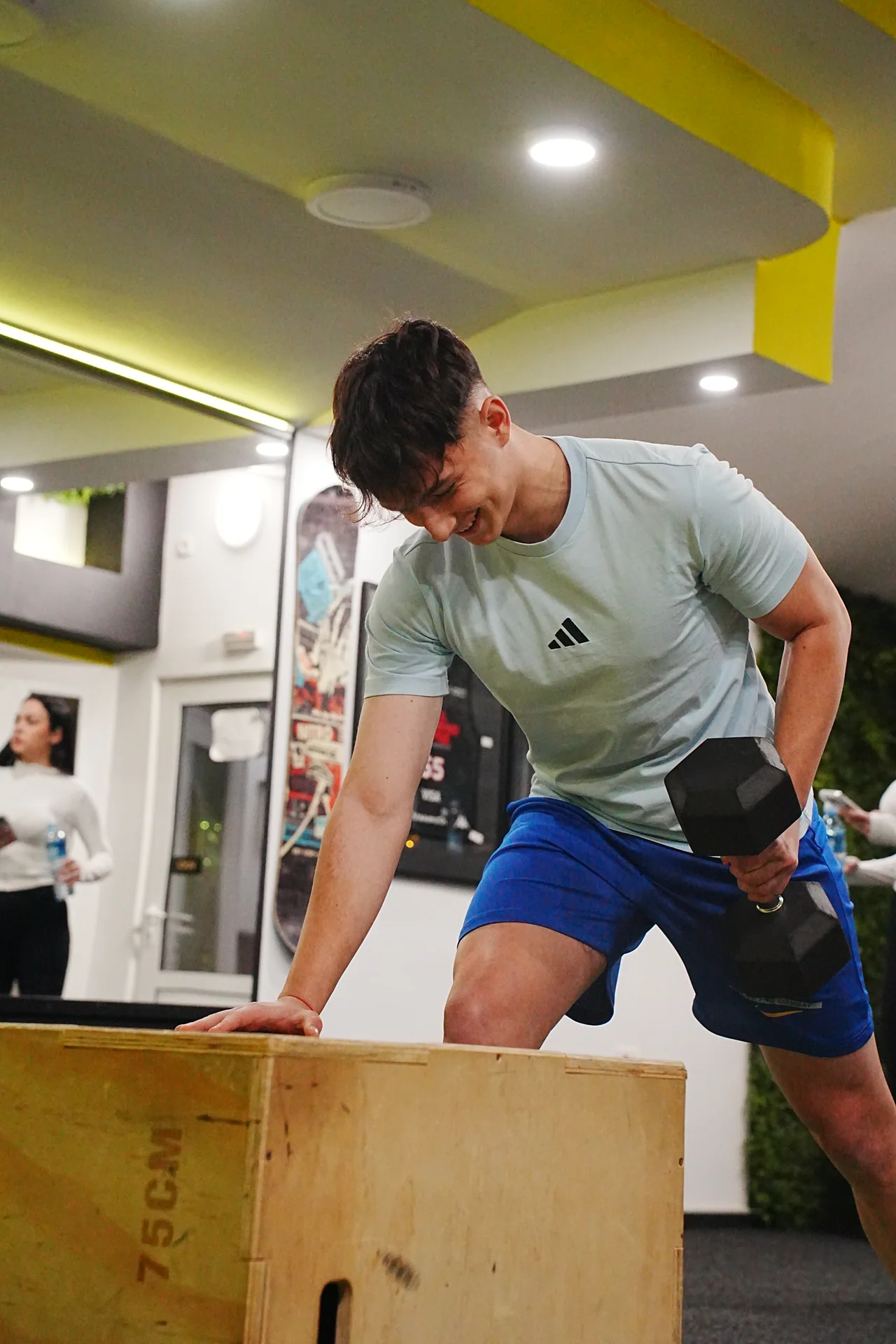 An athlete performs a dumbbell exercise during a personal training session.